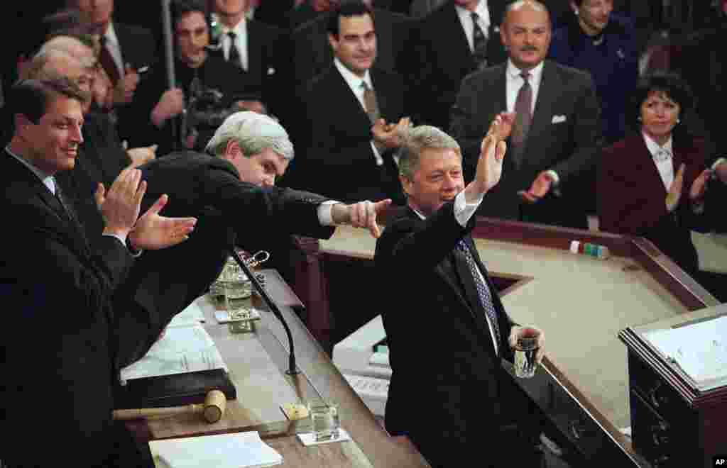 លោកប្រធានាធិបតី Bill Clinton ទទួលស្វាគមន៍អ្នកចូលរួម ខណៈពេលដែលលោកត្រៀមខ្លួនថ្លែងសុន្ទរកថាស្តីពីស្ថានភាពប្រទេសជាតិជាលើកទី២ នៅមុខសមាជិករដ្ឋសភាអាណត្តិទី១០៤ កាលពីថ្ងៃទី២៤ ខែមករា ឆ្នាំ១៩៩៥។ លោក Gore (ស្តាំ) អនុប្រធានាធិបតី និងលោក Newt Gingrich ប្រធានរដ្ឋសភា (កណ្តាល) សម្លឹងទៅមុខ។ (AP/Doug Mills)