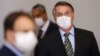 Le président brésilien Jair Bolsonaro avant une conférence de presse pour annoncer des mesures visant à freiner la propagation du coronavirus, Brasilia, 18 mars 2020. (REUTERS/Adriano Machado)
