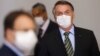 Le président brésilien Jair Bolsonaro portant un masque avant une conférence de presse pour annoncer des mesures judiciaires fédérales visant à freiner la propagation du coronavirus, Brasilia, 18 mars 2020. (Reuters/Adriano Machado)