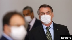 戴着口罩的巴西总统博索纳罗在巴西利亚出席一个宣布采取抗疫措施的新闻发布会。（2020年3月18日）