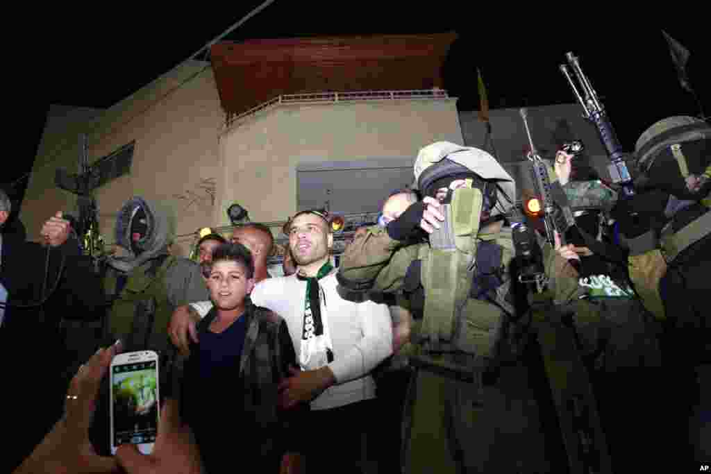 Released Palestinian prisoner Mohammed Sabbagh is surrounded by militants as he greets the crowd at his home in the West Bank refugee camp of Jenin, Oct. 30, 2013.