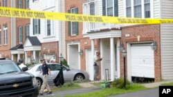 Law enforcement officers gather outside the home of Nicholas Young, a Washington Metro Area Transit officer, in Fairfax, Virginia, Aug. 3, 2016.