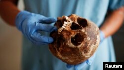 FILE - A forensic expert of the International Commission on Missing Persons (ICMP)works on trying to identify the remains of a victim of the Srebrenica massacre, at the ICMP centre near Tuzla July 9, 2012.