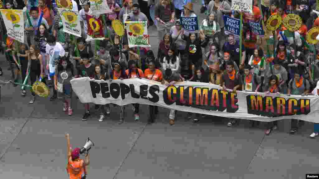 Activists hold a banner as they lead a march of tens of thousands down Sixth Avenue during the People's Climate March through Midtown, New York City, Sept. 21, 2014. 