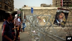 2013年7月9日埃及被罢黜总统穆尔西的支持群众在开罗郊区的纳赛尔城共和国卫队营地外面示威。