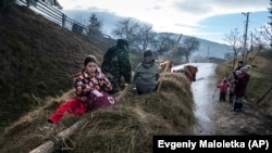 Dr. Viktoria Mahnych rides a horse-pulled cart to visit a patient with COVID-19 in Verhovyna village, Ivano-Frankivsk region of Western Ukraine, Wednesday, Jan. 6, 2021. (AP Photo/Evgeniy Maloletka)