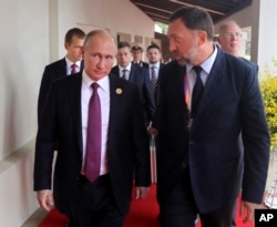 FILE - Russia's President Vladimir Putin, left, and Russian metals magnate Oleg Deripaska, right, walk to attend the APEC Business Advisory Council dialogue in Danang, Vietnam, Nov. 10, 2017.