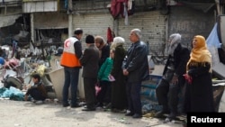 A la espera de ayuda humanitaria en el campo de refugiados palestinos en Yarmouk, en Damasco.