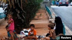 Homeless Syrian refugees rest by the side of a road in Beirut, July 22, 2013.
