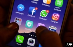 FILE - This photo taken on March 22, 2018 shows apps for WhatsApp, Facebook, Instagram and other social networks on a smartphone in Chennai.