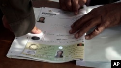 FILE - An Afghan man marks his application for voter registration with his fingerprint, Sept. 16, 2013.