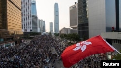 9月29日，香港抗议者封堵了通往金融区的道路。他们不顾警方用催泪弹和警棍发动的攻击举行大规模集会。图为参加集会的一名抗议者挥舞香港旗帜。