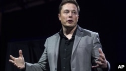 FILE - Tesla Motors CEO Elon Musk unveils the company's newest products, in Hawthorne, Calif., April 30, 2015. Tesla Motors and SolarCity are going to sell solar roof tiles that are customizable and meant to look like a traditional roof.