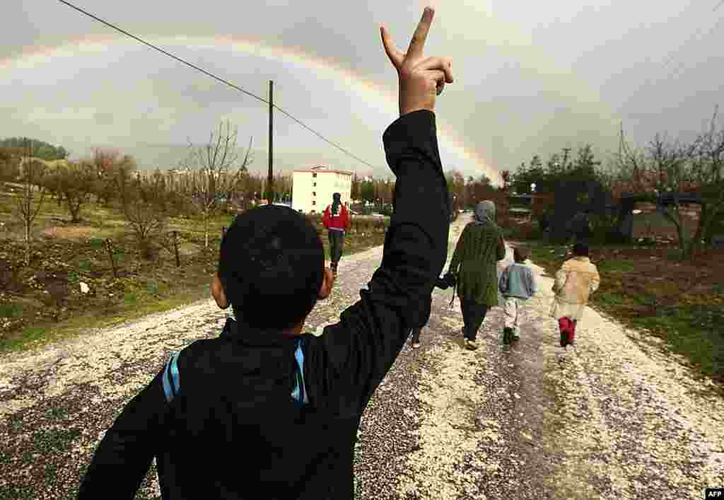 Em Hassan Saad, 13 tuổi, trốn khỏi thành phố Idlib, ra dấu chiến thắng trong khi đi bên ngoài trại tị nạn gần biên giới Thổ Nhĩ Kỳ-Syria, ngày 16 tháng 2 năm 2012. (Reuters)