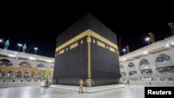 Des agents de sécurité saoudiens devant la Kaaba à la Grande Mosquée vide, à titre de mesure préventive contre la maladie COVID-19. (Photo Saudi Press Agency/Handout)