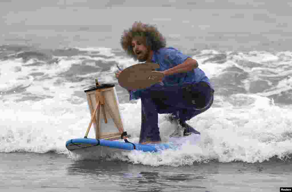 David Nickerson, 28, competes dressed as artist Bob Ross during the ZJ Boarding House Halloween Surf Contest in Santa Monica, California, Oct. 26, 2013.