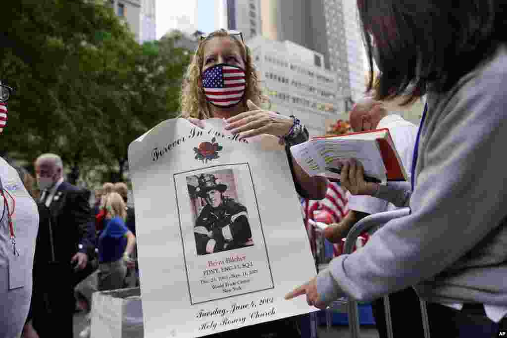 Lorna O&#39;Hara holds a poster of her cousin, Brian Bilcher, a New York City firefighter who died on Sept. 11, 2001, during the attacks at the World Trade Center, before a ceremony organized by the Tunnel to Towers Foundation, Friday, Sept. 11 2020, in New York. The names of nearly 3,000 victims of the Sept. 11, 2001 terror attacks are being read by family members. (AP Photo/Mark Lennihan)