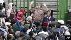 An immigration official addresses Zimbabweans as they queue in the rain outside immigration offices in downtown Johannesburg, as they attempt to become legal before what they fear will be a wave of deportations, 15 Dec 2010