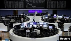 Traders work in front of the German share price index, DAX board, at the stock exchange in Frankfurt, Germany, May 18, 2017.