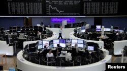 Traders work in front of the German share price index, DAX board, at the stock exchange in Frankfurt, Germany, May 18, 2017. 