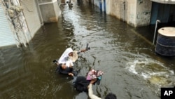 Pakistani men wade through floodwaters in Sujawal in southern Sindh province, Pakistan, 30 Aug 2010.