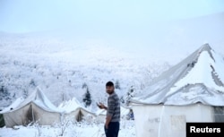 A migrant stands at a snow covered makeshift forest camp near the Croatian border in Bihac, Bosnia and Herzegovina December 3, 2019. REUTERS/Dado Ruvic