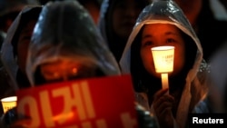 Protesters take part in a candlelight protest demanding South Korean President Park Geun-hye step down over a recent influence-peddling scandal, in central Seoul, South Korea, Nov. 18, 2016. 