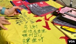 香港市民陳小姐五一勞動節在社民連街站留言支持在囚抗爭者及民主派人士。 (美國之音湯惠芸拍攝)