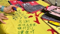 香港市民陳小姐五一勞動節在社民連街站留言支持在囚抗爭者及民主派人士。 (美國之音湯惠芸拍攝)