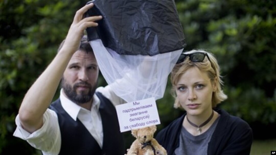 Tomas Mazetti and Hannah Frey with a human-rights message bearing teddy similar to ones they dropped in Belarusian airspace, Germany, Aug. 1, 2012.