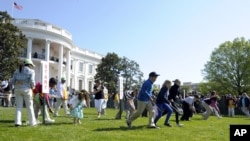 Los niños invitados a la Casa Blanca participan de la tradicional carrera de huevos de Pascua.