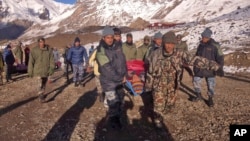 Tentara Nepal mengangkut korban salju longsor di kawasan Himalaya, Rabu (15/10).