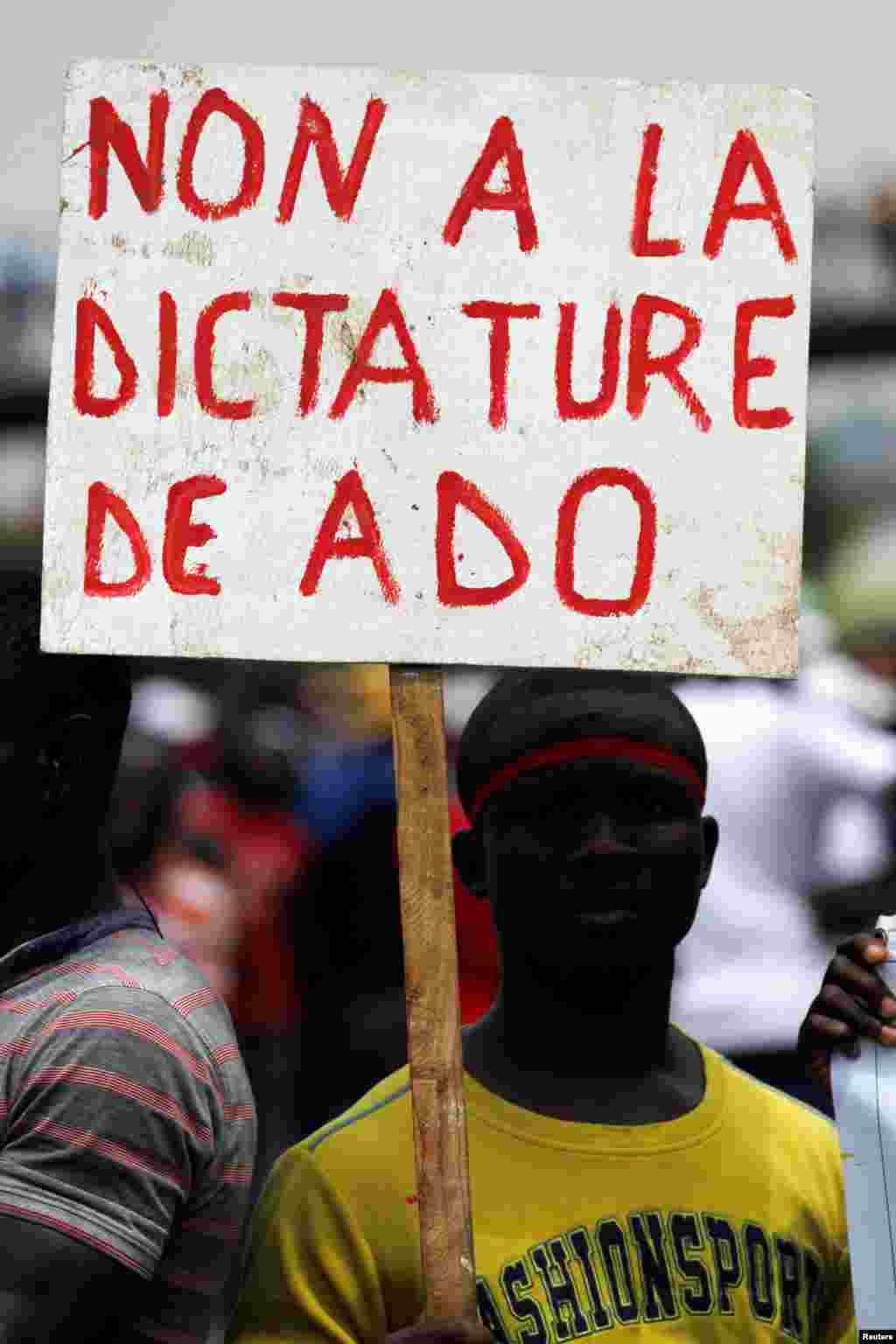 Un manifestant tient une pancarte alors que les gens protestent avant le référendum sur une nouvelle constitution, à Abidjan, le 28 Octobre 2016.