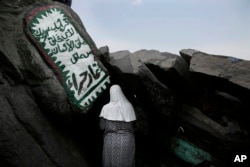 A Turkish Muslim woman prays inside Hiraa cave, where the Prophet Muhammad received his first revelation from God to preach Islam, on Noor Mountain, on the outskirts of Mecca, Saudi Arabia, Sept. 9, 2016.