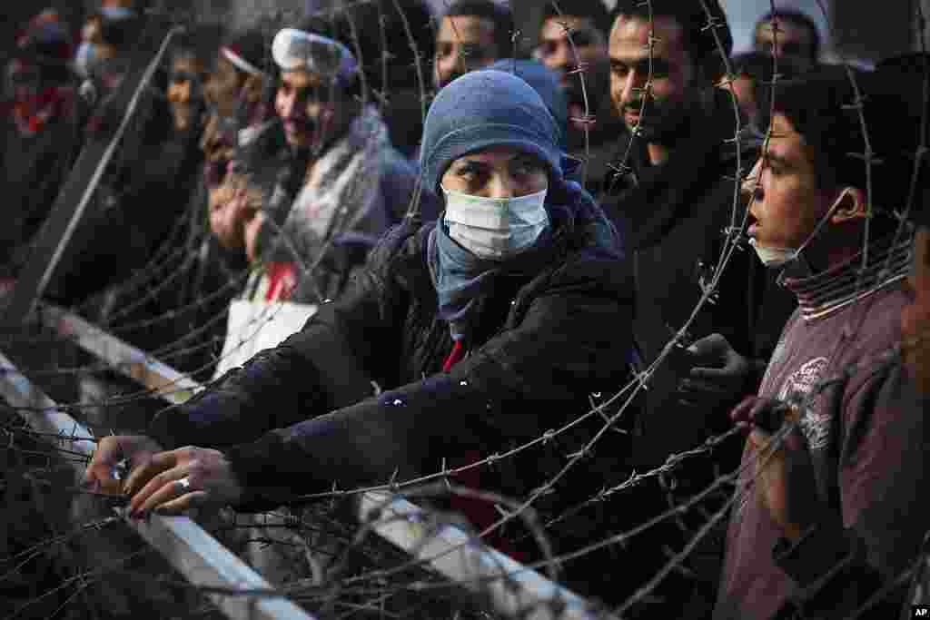 A woman protester attempts to dismantle a barbed wire barricade, newly erected by the Egyptian army, near Tahrir square in Cairo, November 24, 2011. (AP)