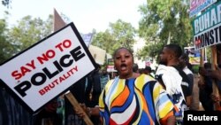 A protester holds a placard as Nigerians mark the one-year anniversary of the EndSARS anti-police brutality protest, in Abuja, Nigeria, Oct. 20, 2021.