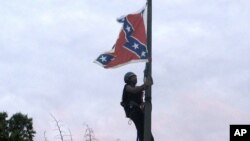 Bree Newsome of Charlotte, N.C., climbs a flagpole to remove the Confederate battle flag at a Confederate monument in front of the Statehouse in Columbia, S.C., June, 27, 2015. 
