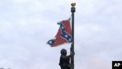 Bree Newsome of Charlotte, N.C., climbs a flagpole to remove the Confederate battle flag at a Confederate monument in front of the Statehouse in Columbia, S.C., June, 27, 2015. 