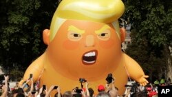 Balon udara setinggi 6 meter yang melambangkan "Bayi Trump" dibawa para demonstran dalam protes anti kunjungan Presiden Trump di Parliament Square, London, Jumat (13/7).