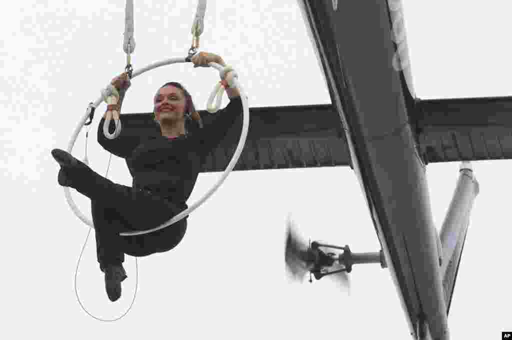 نماش حرکات آکروباتیک توسط دختر آکروبات باز در حالی که معلق از هلیکوپتری بر فراز آبشار نیاگارا است.