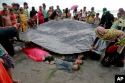 Bangladeshi villagers cover bodies of Rohingya women and children at Shah Porir Deep, in Teknak, Bangladesh, Aug.31, 2017. Three boats carrying ethnic Rohingya fleeing violence in Myanmar have capsized in Bangladesh and 26 bodies of women and children have been found.