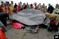 Bangladeshi villagers cover bodies of Rohingya women and children at Shah Porir Deep, in Teknak, Bangladesh, Aug.31, 2017. Three boats carrying ethnic Rohingya fleeing violence in Myanmar have capsized in Bangladesh and 26 bodies of women and children have been found.