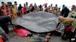 31일 방글라데시 테크낙 마을 주민들이 난민선에서 발견한 로힝야족 여성과 아이들의 시체를 덮고 있다. (자료사진)