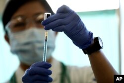 Seorang nakes mengisi jarum suntik dengan vaksin COVID-19 Pfizer-BioNTech di Tokyo Medical Center, Tokyo, Rabu, 17 Februari 2021.