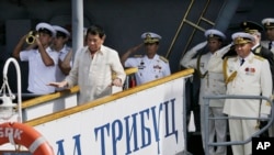Russian Navy and a Philippine officer salute as Philippine President Rodrigo Duterte alights from the Russian anti-submarine Navy vessel Admiral Tributs in Manila, Philippines, Jan. 6, 2017.
