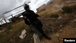 Un oficial de policía peruano participa en una operación para destruir campos de minería de oro ilegales en la localidad de Salpo, en las montañas de Los Andes, La Libertad, Perú, el 25 de mayo de 2016. 