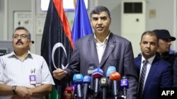 Le ministre de l'Intérieur libyen, le ministre de l'Intérieur Abdessalam Achour (au centre) et le sous-secrétaire du ministère des Communications du gouvernement GNA Hisham Abu Shkiwat (à droite) donnent une conférence de presse à Tripoli, le 17 septembre 2018.