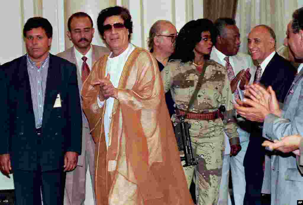 Libyan leader Muammar Gadhafi (C) arrives at Cairo university for a meeting with university professors, The armed woman to the right of Gaddafi is his personal bodyguard, May 27, 1996.