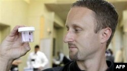 Entomologist Jeff White holds a container of live bed bugs at the North American Bed Bug Summit in Rosemont, Illinois, on September 21