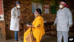 Asnath Masango, derecha, y Carol Ditshego, izquierda, informan a una paciente antes de hacerle una prueba de COVID-19 en la clínica Ndlovu en Elandsdoorn, 200 kms al noreste de Johannesburgo, el jueves 11 de febrero de 2021. 